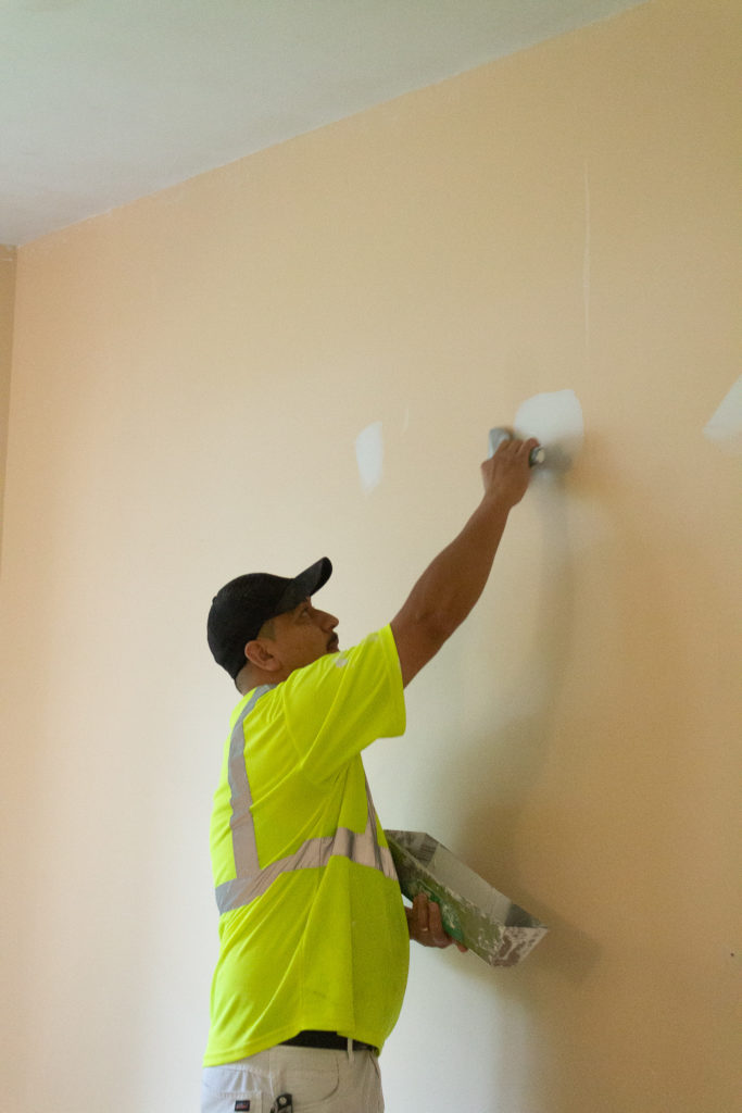 Douglas painting a wall while on a construction job.