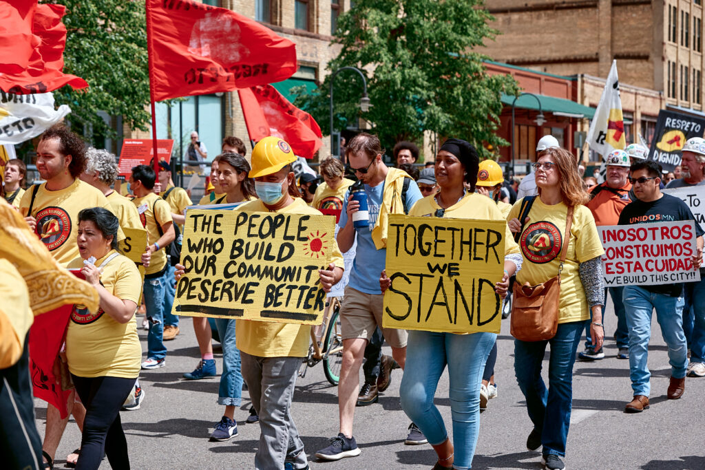 Marchers holding signs in support of construction workers at the March for Dignity and Respect on June 16th 2022.